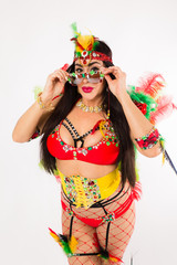 Dark haired hispanic woman in Carnaval costume and athletic shoes posing on clean white background