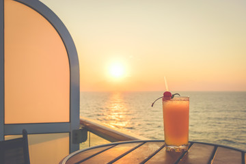 Summer time holiday concept: Refreshing cocktail on a cruise vacation, with stunning sunset view.