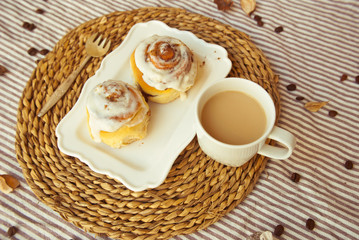 Tasty breakfast with homemade cinnamon roll and fresh coffee. Food background.