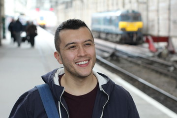 Cute ethnic young man in retro train station