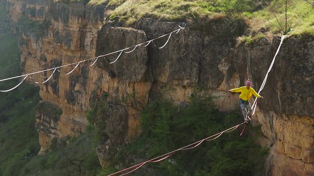 Funambulist at sunset in the mountains enjoying nature. slow motion