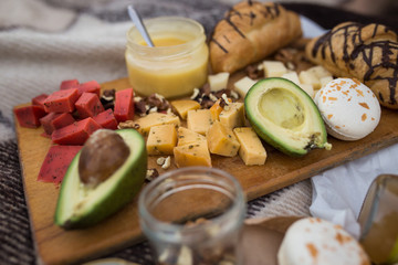 Cheese honey and avocado lie on the dostochke. Eating out at a picnic