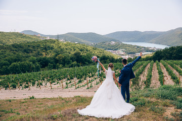The newlyweds are happy to be together, hold each other's hands tightly and enjoy life. The bride...