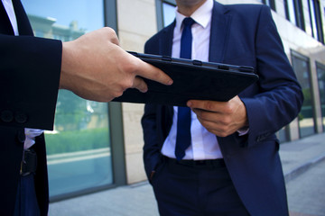 .men hand over to each other in the hands of an electronic book