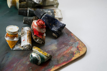 Bright oil paints in a tube on a dirty palette. Paints in use.