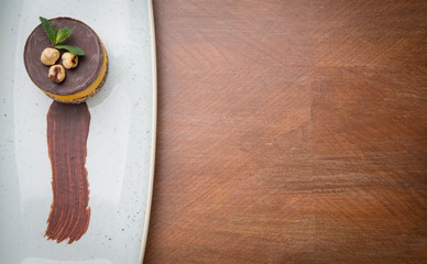 Vegan cake with chocolate and chickpeas on plate over wooden table with copy space