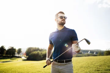 Foto auf Acrylglas Golf player holding a golf club in golf course © VAKSMANV