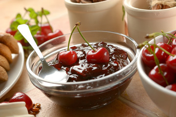 cherry jam in the glass bowl with fruits around