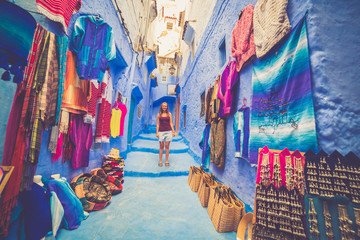 Happy young tourist backpackers on a street in Medina of the blue town of Chefchaouen, Morocco...