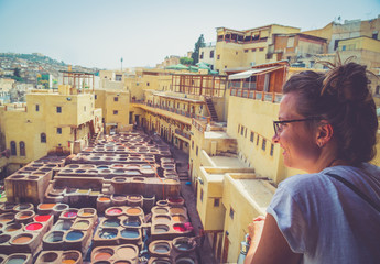 Tourist visiting Fez in the middle of souk, traditional leather tannery from the 11th century is...