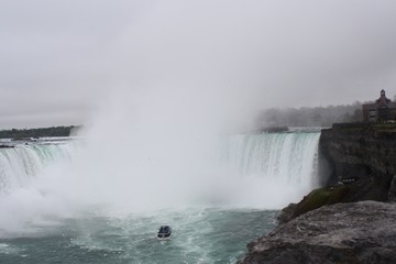 Mist rising from Niagara Falls with boat