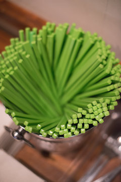 Bright green chopsticks in jar on counter at restaurant