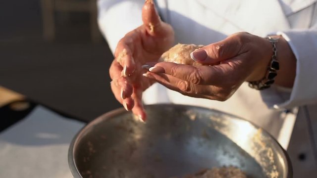 A woman makes a cutlet with fresh ground meat in a home kitchen, slow motion
