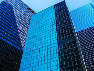 Vertical of modern shiny blue facade of high rise buildings in Manhattan, New York city, USA.