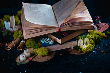 Open book with candles, crystals, and moss. Reading fantasy concept with copy space. Magical still...