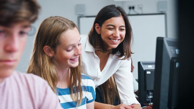 Teenage Students Studying In IT Class With Female Teacher