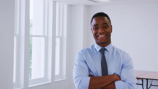 Young black businessman walking into focus in an office