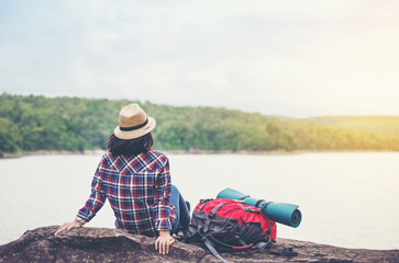 Female tourist with backpack Happy on the hill At sunrise
