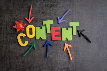 Content is king in brand communication and advertising concept idea, colorful arrows pointing to the word CONTENT at the center with red crown on black cement wall