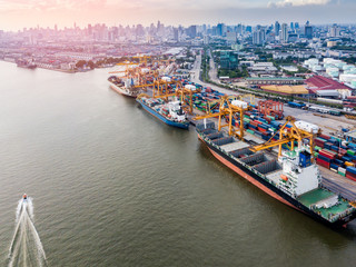 Aerial view of international port with Crane loading containers in import export business logistics.