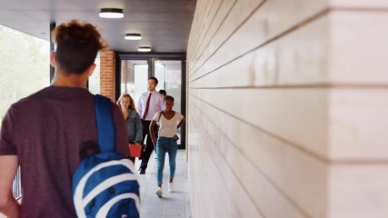 Teenage Students And Teacher Walking Between School Buildings