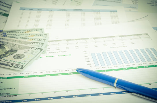 Stack Of Graphic Financial Reports, Market Analysis, Pile Of Ben Franklin 100 Dollar Bills And Blue Pen. Close-up Graphs And Charts. Concept Image Of Invest Planning, Analyze Return On Investment.