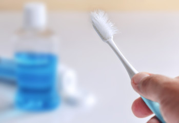 Used toothbrush in hand.