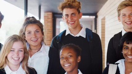 Portrait Of Teenage Students In Uniform Outside School Building