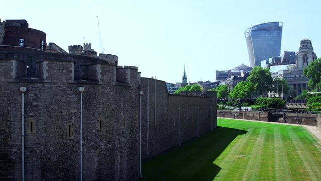 LONDON - MAY, 2017: Exterior wall and lawn at the Tower of London with modern buildings in the background, City of London, London, EC2