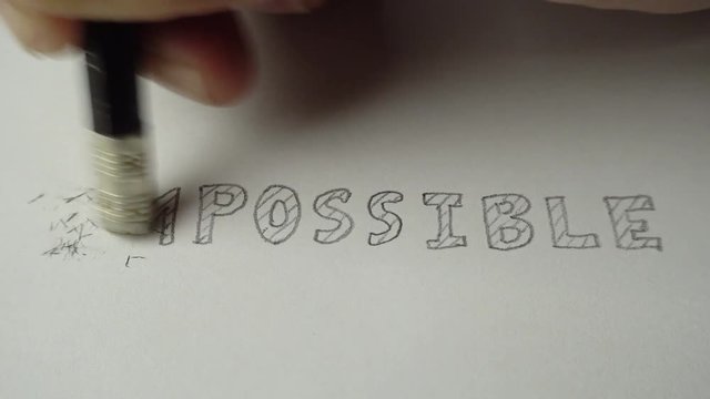 Changing the word impossible to possible. Impossible word gets the ''im'' removed to make it possible. Pencil erase it to possible. Closeup 4K Resolution.