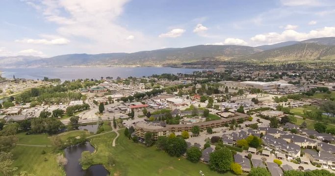 Aerial Dolly Establishing Shot of Small Canadian Town with moving Traffic and Large Lake