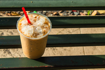 Coffee cool moment the sun is low. On a steel chair in the park