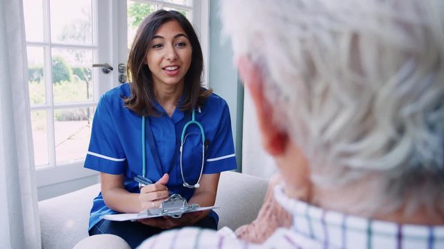 Over shoulder view of nurse on home visit with senior man