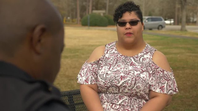 An African American woman talks with a police officer to report a crime she witnessed.