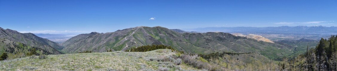 Panoramic view of Wasatch Front Rocky Mountains from the Oquirrh Mountains, by Kennecott Rio Tinto Copper mine, Utah Lake and Great Salt Lake Valley in early spring with melting snow and Cloudscape. U
