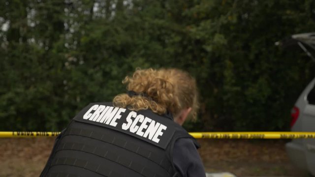 A crime scene investigator takes pictures of a crime scene with a camera.