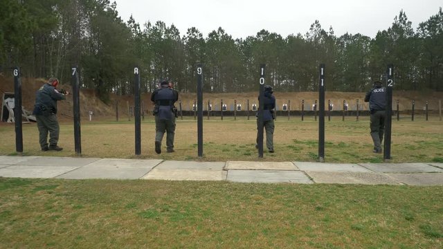 A team of police officers shoot their weapons at a gun range for target practice.