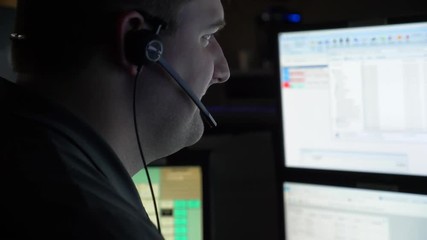 A 911 dispatcher works at his computer station at a control center to help respond to emergency calls.