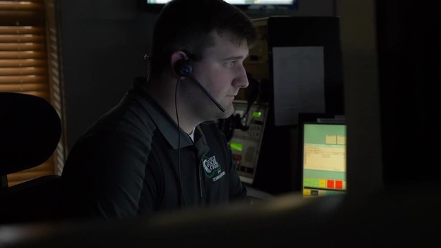 A 911 dispatcher works at his computer station at a control center to help respond to emergency calls.