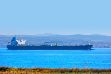 Large cargo ship passing through in Canakkale strait against Canakkale city