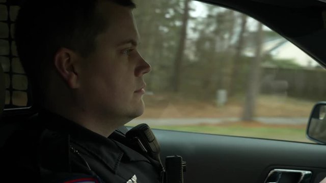 Police officer driving his patrol car to enforce traffic laws.