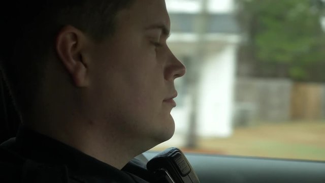 Police officer driving his patrol car to enforce traffic laws.