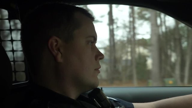 Police officer driving his patrol car to enforce traffic laws.