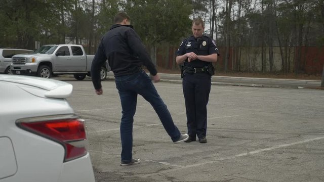 A drunk person tries to pass a DUI test during a traffic stop with a police officer.