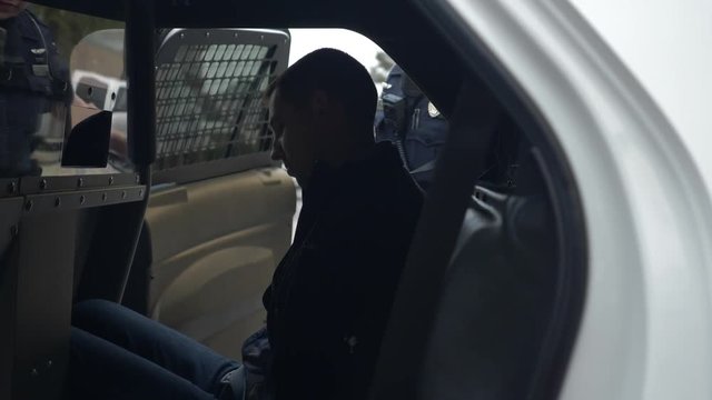 Police officer arrests a drunk driver who failed a DUI test during a traffic stop.