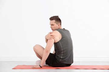 Obraz premium Male athlete suffering from shoulder pain during training indoors
