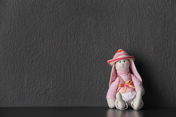 Abandoned toy bunny on table against gray background. Time to visit child psychologist