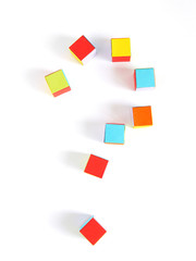 A question mark made of multi-colored paper cubes, origami, top view. Concept school, children, toys, questions.