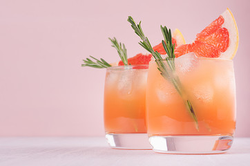 Two elegance cold wet drinking glasses with fresh grapefruit summer alcohol  cocktail, ice,...