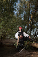 Obraz premium Pirate on the sandy beach with a gun and a saber